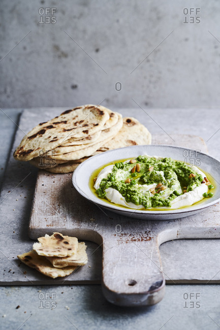 A garden pea dip with yoghurt dip, pine nuts and olive oil with flat bread to dip.