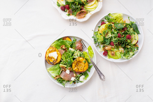 Overhead view of various seasonal summer salads and dressings