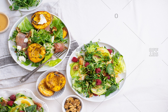 Various summer salads and dressings served on light background
