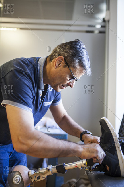 Prosthetic engineer reviewing the prosthesis of a patient and improving the material in his workshop