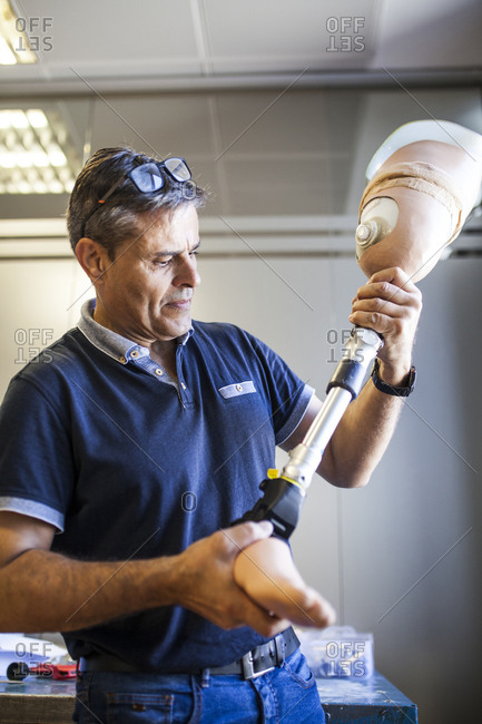 Prosthetic engineer reviewing the prosthesis of a patient and improving the material in his workshop