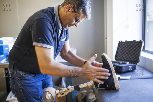 Prosthetic engineer reviewing the prosthesis of a patient and improving the material in his workshop
