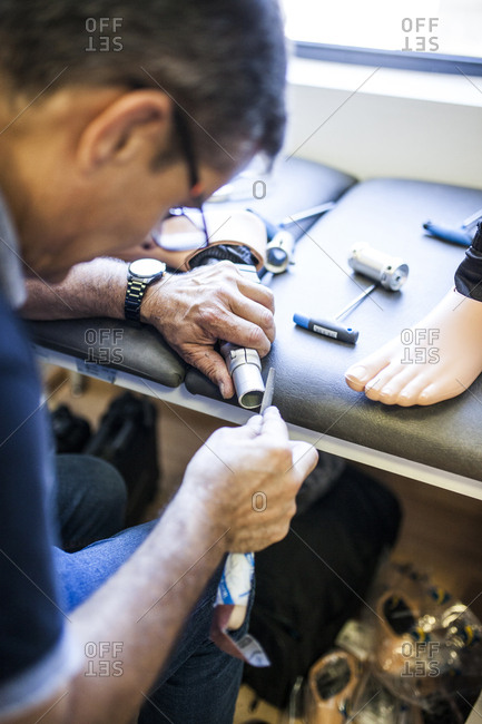 Prosthetic engineer reviewing the prosthesis of a patient and improving the material in his workshop