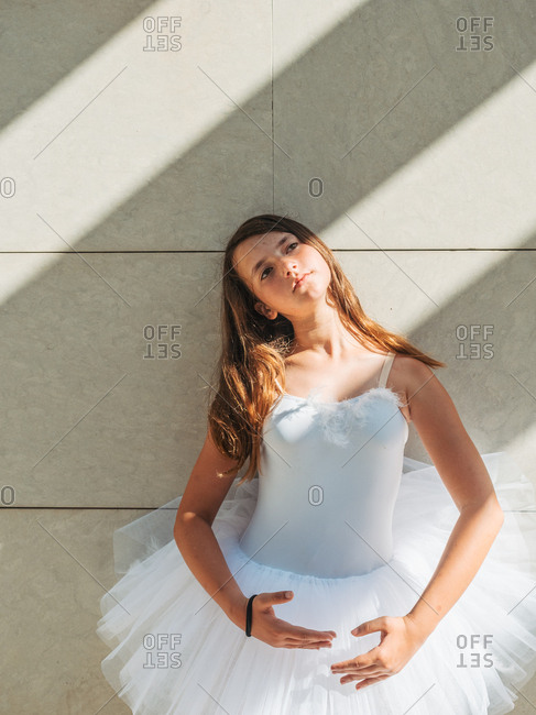 Ballerina standing in classical position near wall