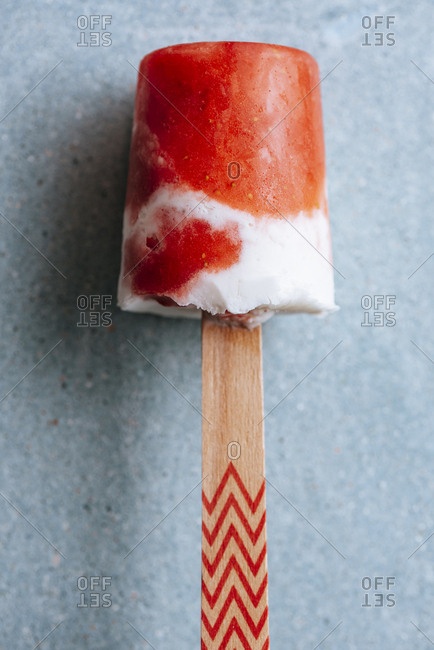 Close-up view of watermelon and cream popsicle laying on fancy plate