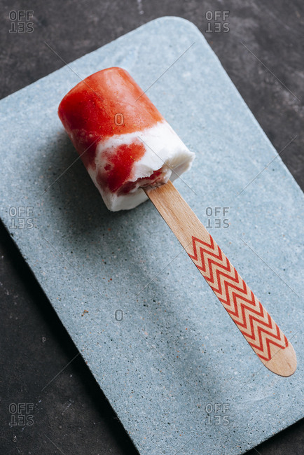 Close-up view of watermelon and cream popsicle laying on fancy plate