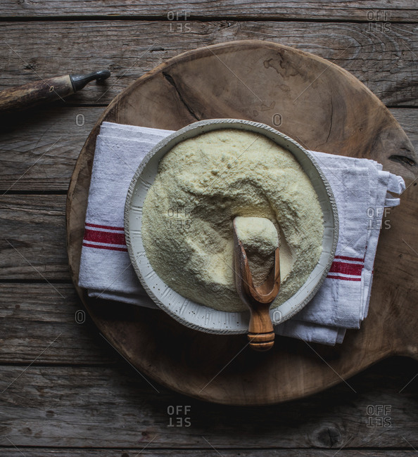 From above baking dish with corn flour for cooking on cutting board on wooden background