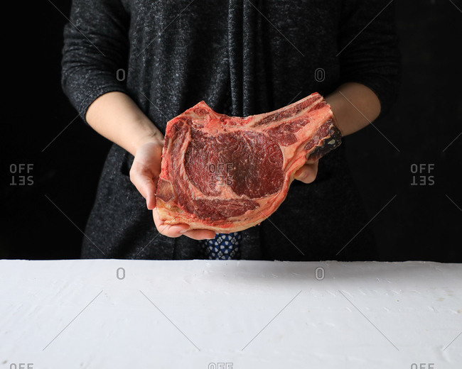 Tasty appetizing piece of fresh meat on bone in hands