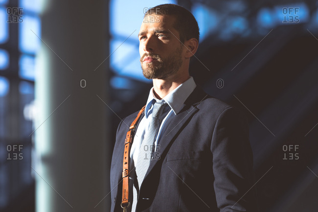 Close-up of businessman with office bag looking away in a modern office building