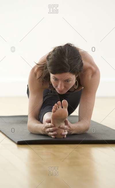 A woman practices yoga in a studio.