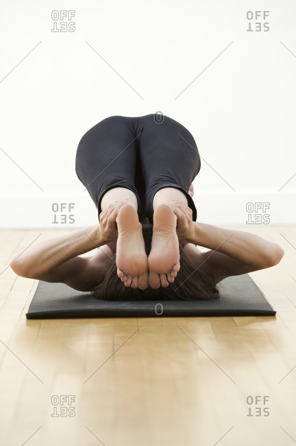 A woman practices yoga in a studio.