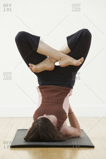 A woman practices yoga in a studio.