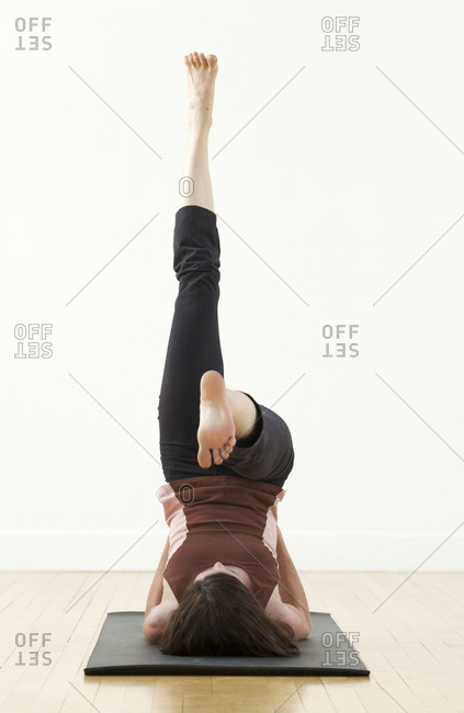 A woman practices yoga in a studio.