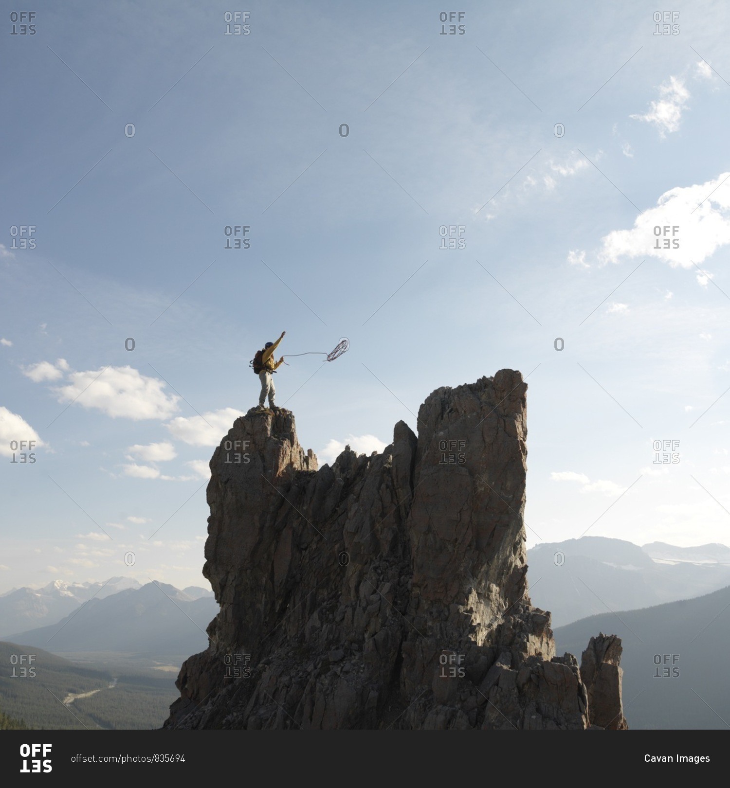 Mountaineer throws rope, mountain summit