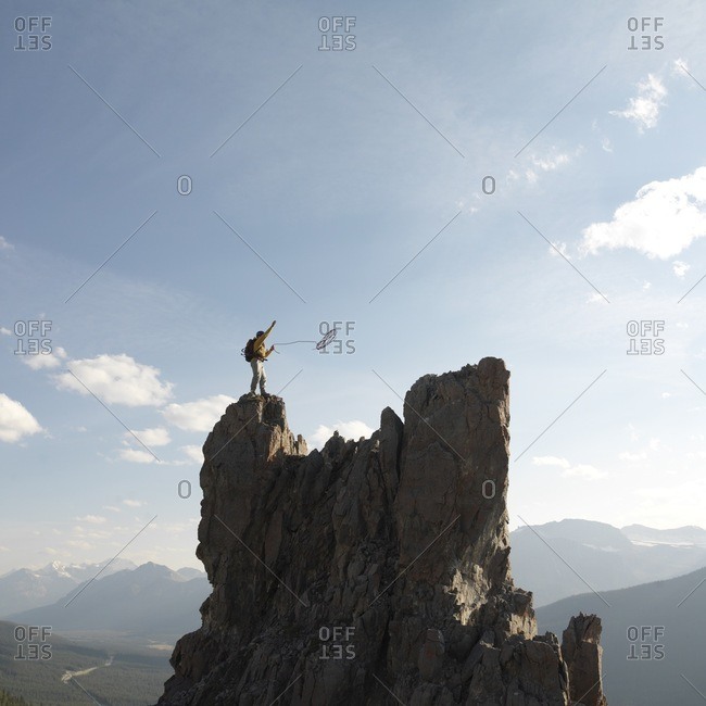 Mountaineer throws rope, mountain summit