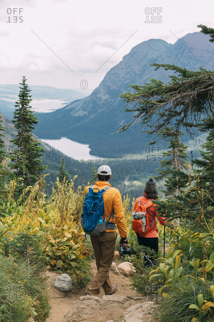 Couple's hiking beautiful trail in Glacier National Park, Montana
