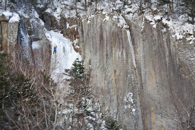 A man is climbing a frozen waterfall in Sounkyo Gorge, Daisetsuzan National Park, Hokkaido, Japan.