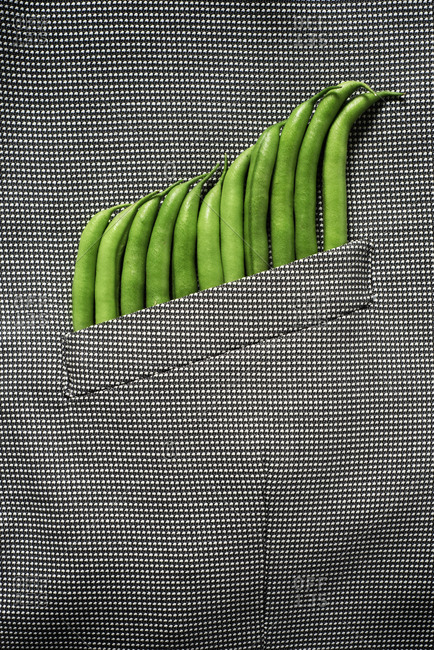 Some raw green beans peeking out from the pocket of a formal jacket