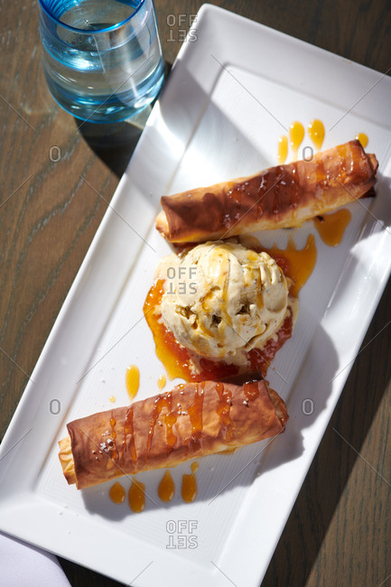 Galaktoboureko with ice cream served at a greek themed restaurant with a scoop of praline ice cream.