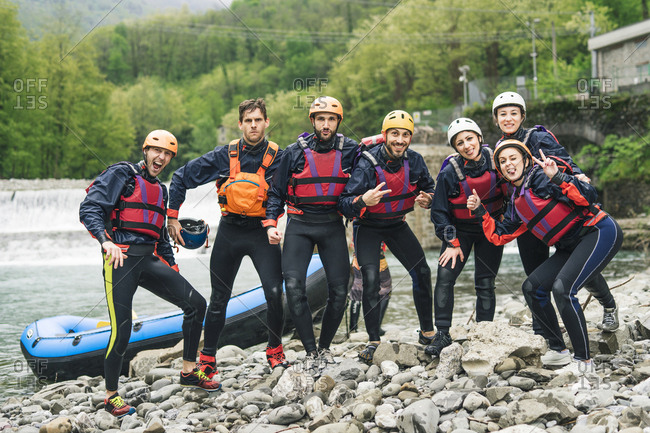 Group of playful friends at a rafting class posing at boat