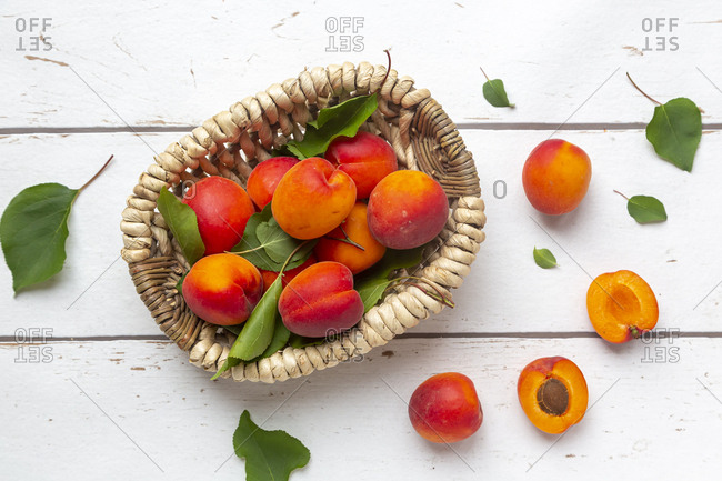 Apricots in basket on white wood