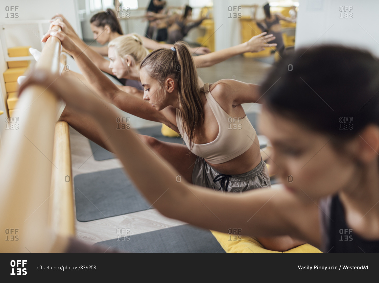 Young women doing barre workout in gym