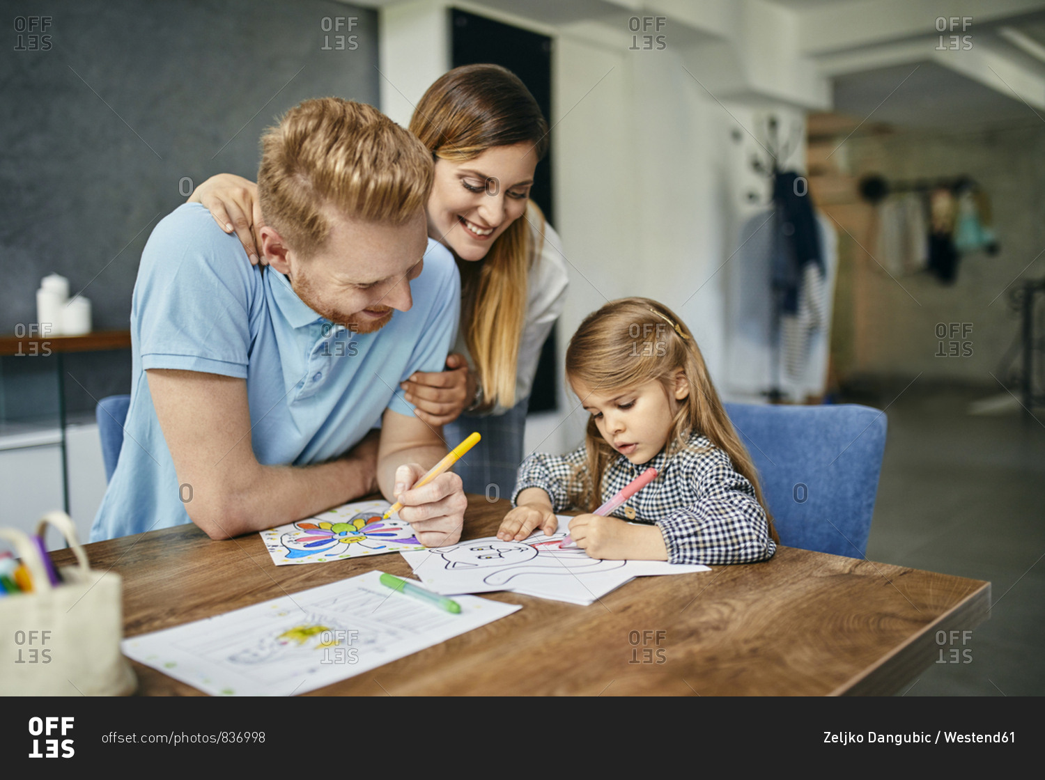 Mother and father watching daughter- painting coloring book