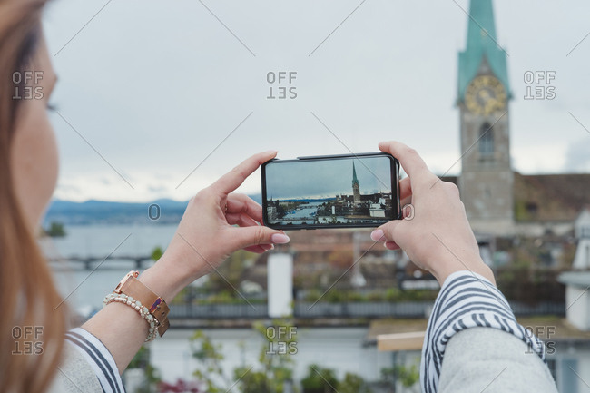 Young woman taking smartphone picture in the city- Zurich- Switzerland