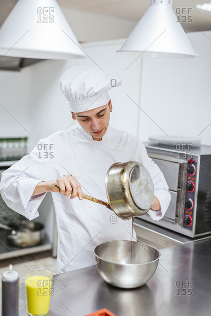 Junior chef preparing a dessert- bowl with chocolate sauce