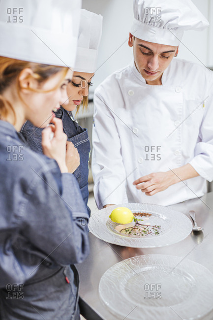 Junior chef showing his prepared dessert on plate