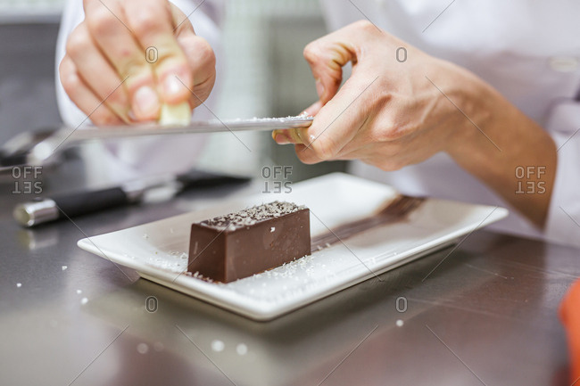 Junior chef preparing a dessert- grating coconut