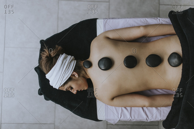 Young woman with heated stones on her back