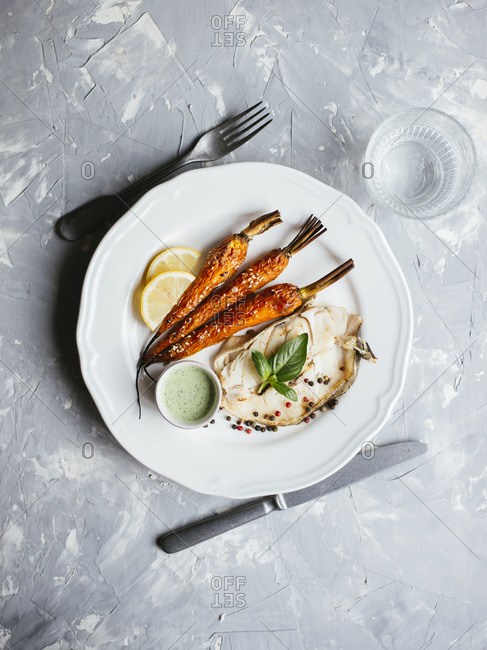 Fried codfish steak served with roasted carrot and sour cream basil salsa