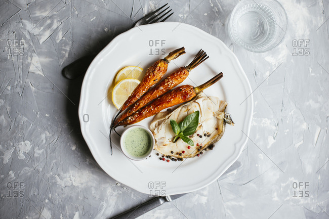 Fried codfish steak served with roasted carrot and sour cream basil salsa