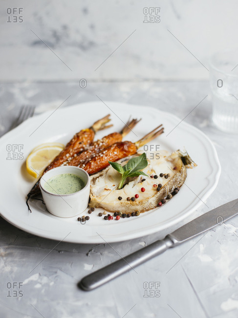 Fried codfish steak served with roasted carrot and sour cream basil salsa