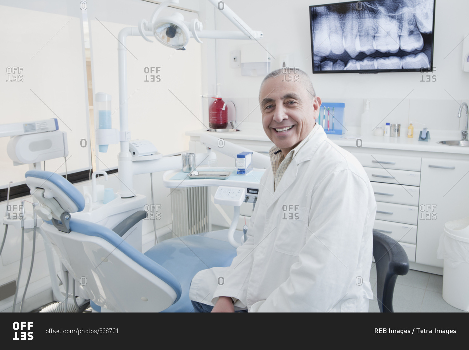 Dentist smiling in dentist\'s surgery