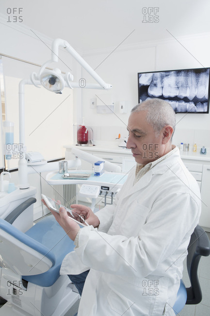 Dentist using digital tablet in dentist's surgery