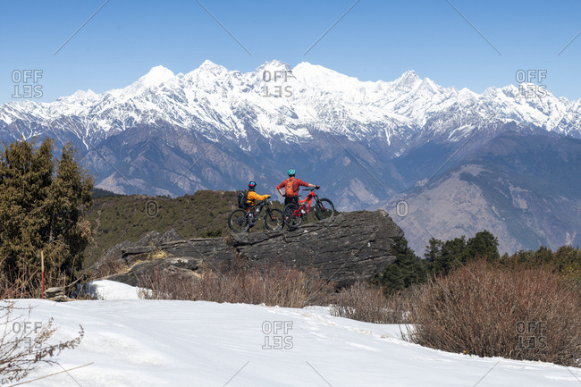 Gosainkund, Nepal - March 28, 2019: Mountain bikers taking in views of the Langtang range in the distance in the Himalayas