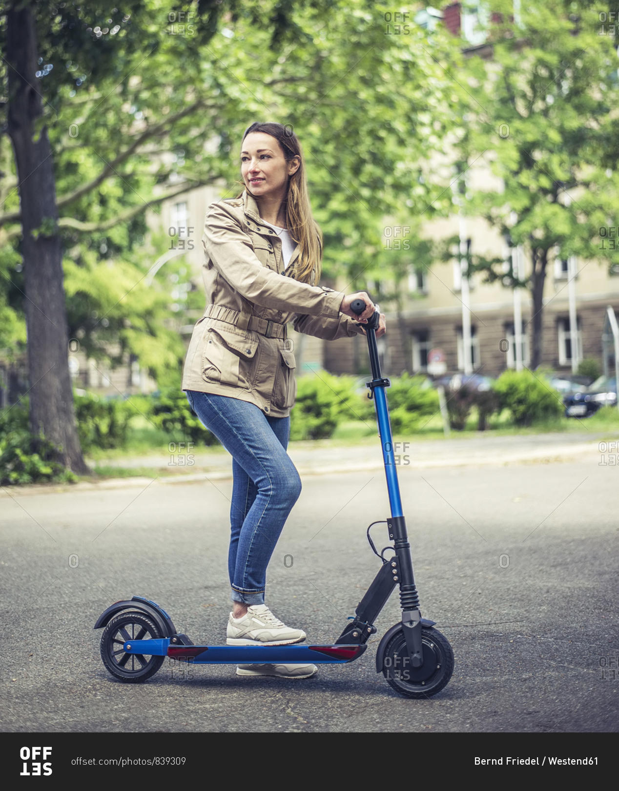 Portrait of smiling woman with E-Scooter