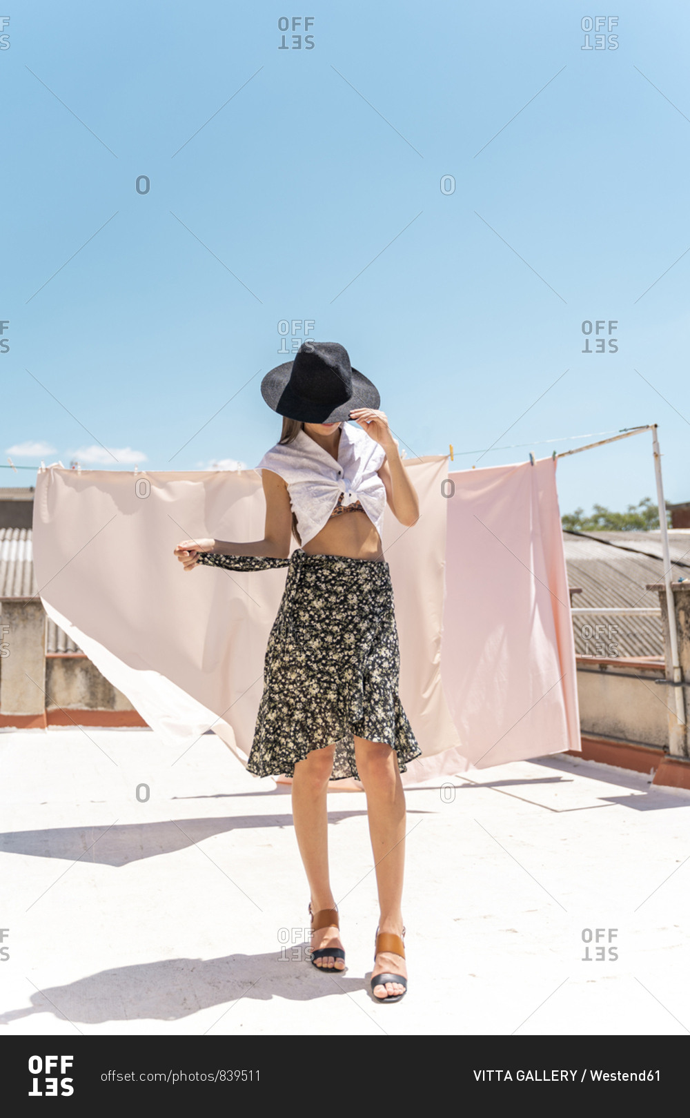 Fashionable young woman wearing hat- wrap-around blouse and skirt with floral design