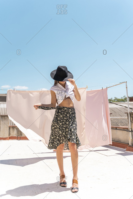 Fashionable young woman wearing hat- wrap-around blouse and skirt with floral design