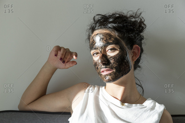 Portrait of young woman wearing facial mask at home