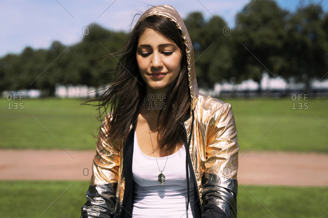 Portrait of young woman wearing shiny jacket- hood
