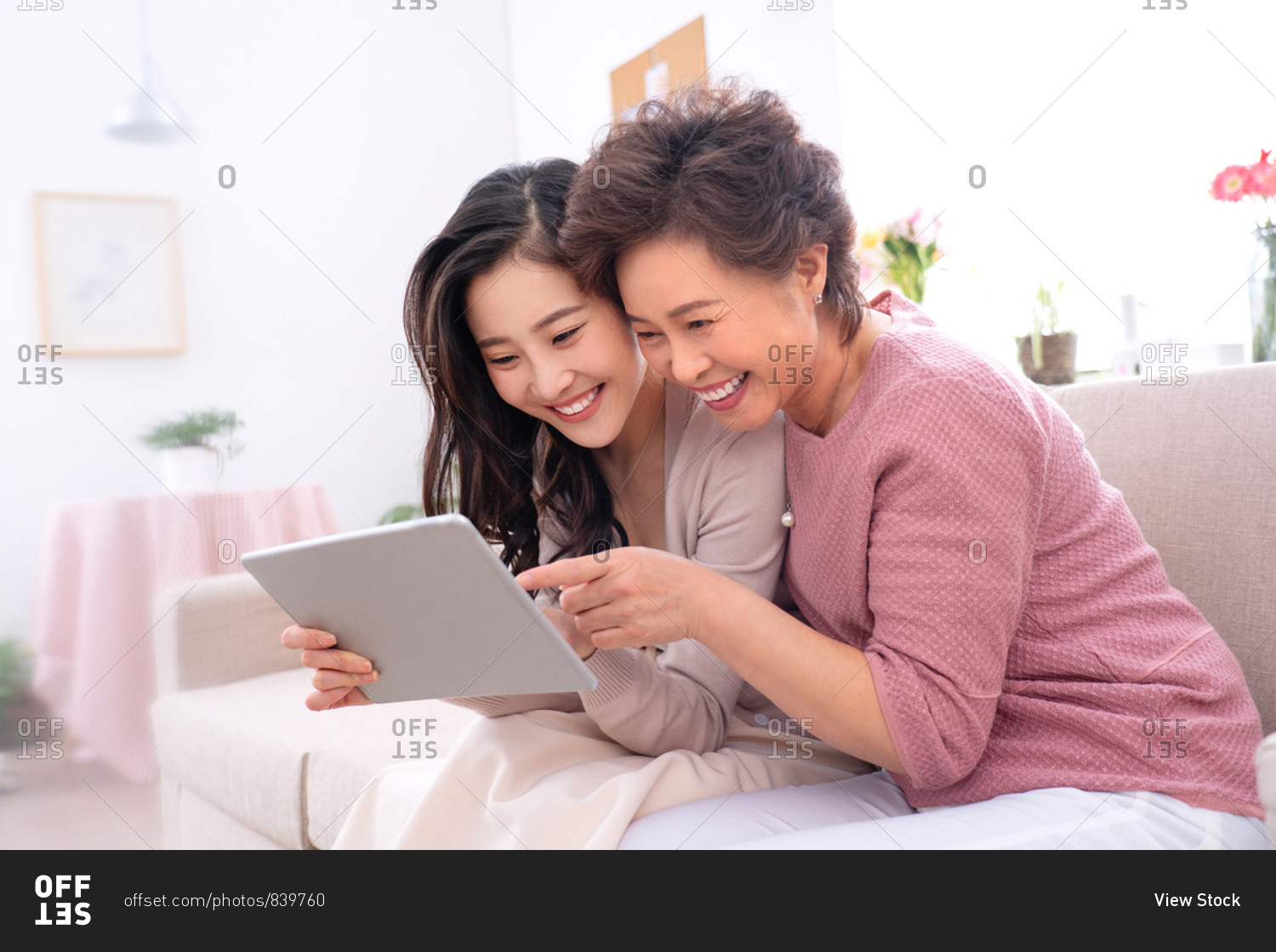Happy mother and daughter see tablets