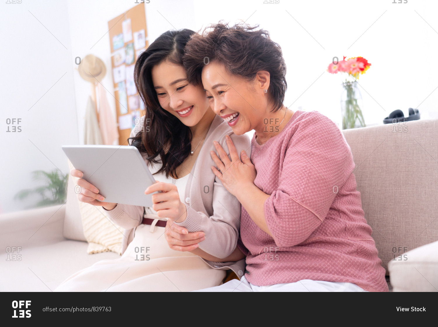 Happy mother and daughter see tablets