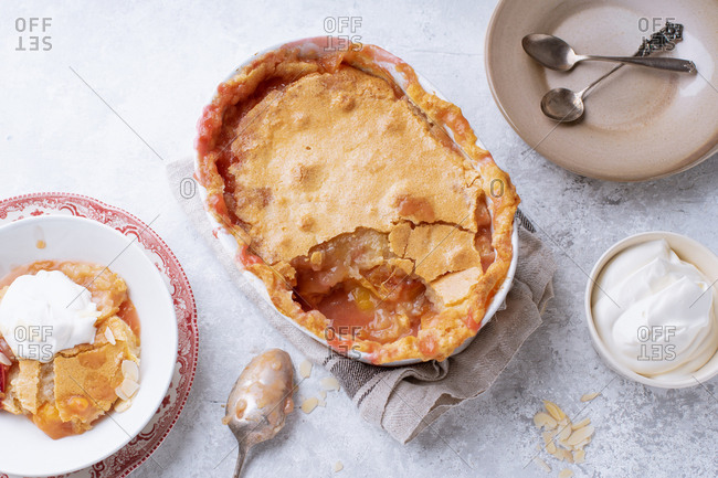 Peach cobbler with hot sugar crust and whipped cream