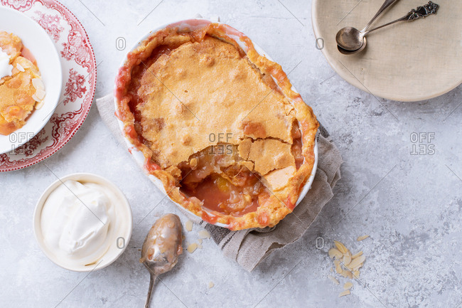 Peach cobbler with hot sugar crust and whipped cream