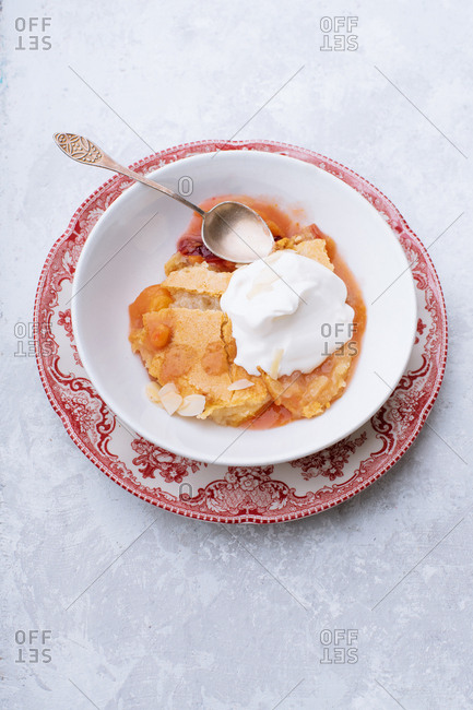 Peach cobbler with hot sugar crust and whipped cream