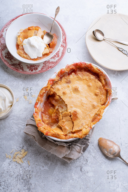Peach cobbler with hot sugar crust and whipped cream
