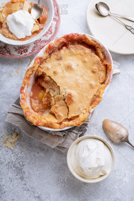 Peach cobbler with hot sugar crust and whipped cream